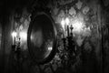 Candlestick and mirror on the wall. Black and white photo.