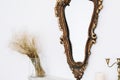 Candlestick on old books near big mirror on the fireplace. Interior details