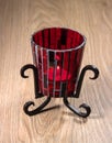 Candlestick from red glass on a metal stand. Royalty Free Stock Photo