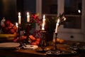 Candlesticks with candles on wooden table.romantic setting for dinner in kitchen Royalty Free Stock Photo