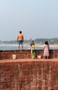 Indian tourists enjoying the view of the sea on the walls of the ancient Portuguese era fort