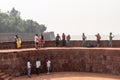 Large group of Indian tourists enjoying the view of the sea on the walls of the ancient