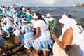 Candomble supporters walk on top of the rocks on Rio Vermelho beach to offer gifts to Yemanja