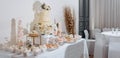 Candy bar at the banquet. Wedding table with sweets, cake, pastries, muffins, sugar treats. Event in the restaurant