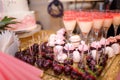 candy bar with cupcakes, macarons, coctail glasses and strawberries in chocolate glaze. Unfocused pink cake Royalty Free Stock Photo