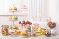 Candy bar with different sweets on white table against blurred