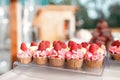 Candy bar. many mini vanilla cupcakes with flavoured buttercream decorated with fresh raspberries in a line on table. Royalty Free Stock Photo