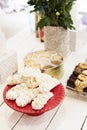 Candy bar Table with sweets, candies, dessert. French meringue cookies in red high plateau, tray. Egg white sweets, biscuits and f