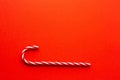 Christmas background.A candy cane on a red background, Royalty Free Stock Photo