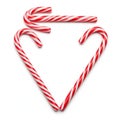 Candy canes creatively arranged to form a heart shape on a plain background Royalty Free Stock Photo
