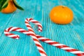 Candy canes heart and tangerines on wooden planks, xmas background