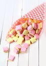 Candy cone spilling square marshmallows on a table Royalty Free Stock Photo