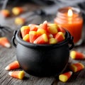 Candy corn in a cauldron with a candle, Halloween decor. Royalty Free Stock Photo