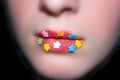 Candy flowers on lips, blured face. Royalty Free Stock Photo