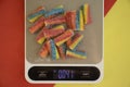 Candy , kitchen scales on a colored background Royalty Free Stock Photo