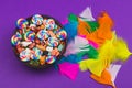 Candy pebbles in a bowl and lollipops. spiral candies and sweets in the form of colored stones. colorful feathers