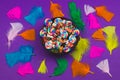 Candy pebbles in a bowl and lollipops. spiral candies and sweets in the form of colored stones. colorful feathers