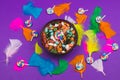 Candy pebbles in a bowl and lollipops. spiral candies and sweets in the form of colored stones. colorful feathers