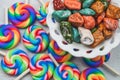 Candy pebbles in a bowl and lollipops. spiral candies and sweets in the form of colored stones