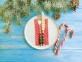 Candy, plate Christmas tree branches gift box on a blue wooden background, fork, knife, banquet, menu Royalty Free Stock Photo