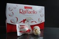 Candy and a square rectangular gift box by Raffaello stands on a black background side view of copy space Royalty Free Stock Photo