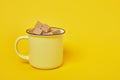 Cane brown sugar cubes in a yellow cup on a yellow background Royalty Free Stock Photo