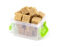 Cane brown sugar isolated on a white background. Cane sugar in a container. Plastic container with cane sugar