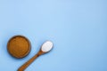 cane brown sugar in a wooden bowl white crystalline sugar in a wooden spoon on a blue background with copy space Royalty Free Stock Photo