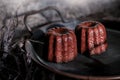 Caneles de bordeaux on dark background with sunrise.