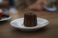 Caneles de bordeaux in white plate on wooden table. Traditional French sweet dessert