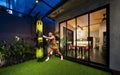 Canggu, Bali, Indonesia, 16 July 2021. A young boxer trains at a punching bag. New architecture, beautiful modern house Royalty Free Stock Photo