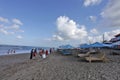 Canggu, Indonesia - May 27, 2019: Tourist enjoying sunny day in the beach and local students join the beach cleaning activity