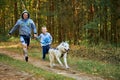 Canicross cross country running with dog, father and son running with Husky dog, family sports