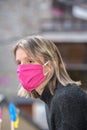 Blonde woman with face mask worried about the Covid-19 outbreak staying at home. Royalty Free Stock Photo