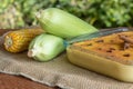 Canjica. Curau. Typical Brazilian junina party sweets. Corn cobs. Blurred green background. Brazilian dessert