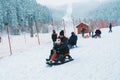 Child, mother and other people sledding in Ilgaz Yildiztepe Ski Center