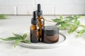 Cannabis face cream and serum or oil dropper concept. Natural cosmetic. CBD oil, THC tincture and hemp leaves on a