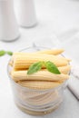 Canned baby corns with basil on light grey table, closeup Royalty Free Stock Photo