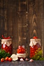 Canned cherry tomatoes fall into a jar on a wooden background with space for text Royalty Free Stock Photo
