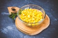 Canned corn in a glass plate on a gray concrete background. Royalty Free Stock Photo