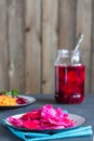 Canned fermented cabbage with beets, carrots on a white plate in a vertical orientation. Natural wooden background Royalty Free Stock Photo