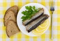 Canned fish, lemon, parsley in plate and pieces of bread
