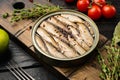 Canned fish in tin can with sardine, on black wooden table background Royalty Free Stock Photo