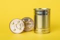 Canned food on a yellow background, closed shiny golden cans. Tinned goods. Metallic jars. Preserves, conserve