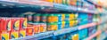 Canned goods neatly arranged on grocery store shelves with colorful packaging