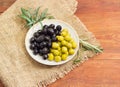 Black and green olives and olive branches on wooden surface Royalty Free Stock Photo