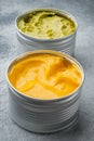 Canned guacamole and cheese dip, on gray background