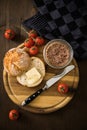 Canned liver sausage spread from long term pantry with crispy bread roll bun, butter, tomatoes and knife for snack or breakfast on