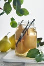 Canned pear compote with vanillin. Pear compote. Homemade delicious canned pear compote in glass jars at home on a light