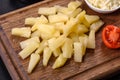 Canned pineapple chunks in a white bowl on a dark concrete background